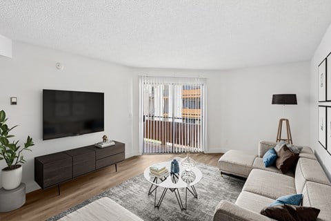 A living room with a flat screen TV mounted on the wall.