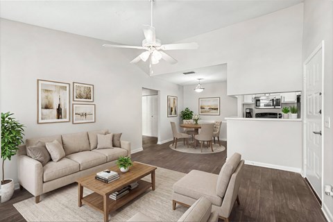 A living room with a beige couch, a coffee table, and a ceiling fan.
