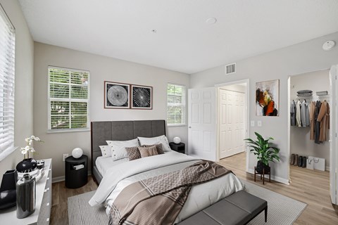 A bedroom with a large bed and a clothing rack.