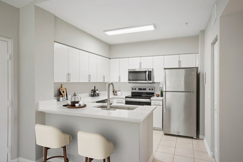 A modern kitchen with white cabinets and appliances.