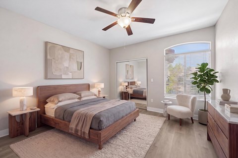 A bedroom with a large bed and a ceiling fan.