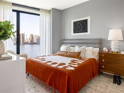 a bedroom with a bed and a city view
