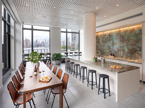 A modern dining room with a long table set for a meal.