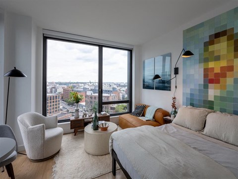 a bedroom with a bed and a couch and a window