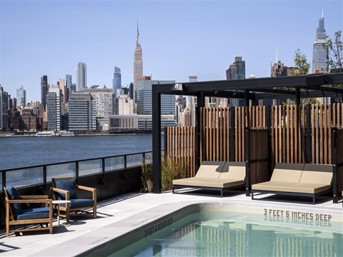 a rooftop pool with a view of the city and the empire state building
