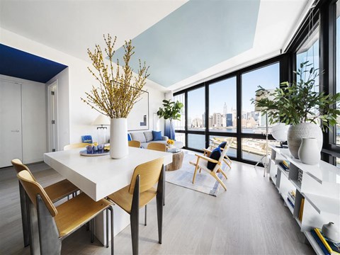 a dining room with a white table and chairs and a large window