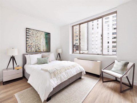 a bedroom with a bed and a large window