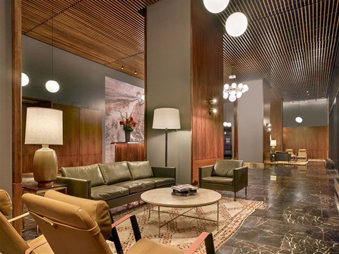 A modern living room with a green sofa and a wooden ceiling.