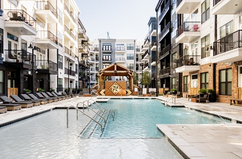 A swimming pool in the middle of a courtyard surrounded by buildings.