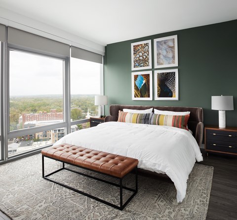 A bedroom with a large bed and a bench in front of it.