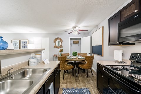 A kitchen with a dining table and chairs.