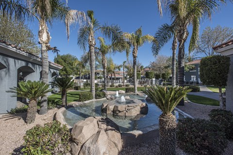 a fountain in a courtyard with palm trees