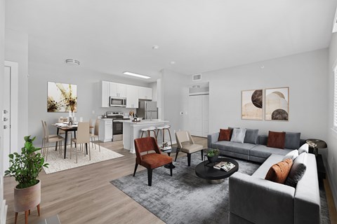 A modern living room with a grey sofa and a dining table with chairs.