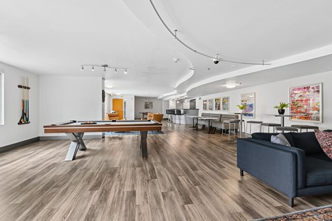 A living room with a pool table and a couch.