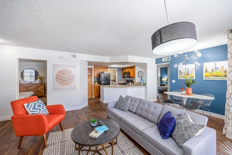 A living room with a grey couch and a red chair.
