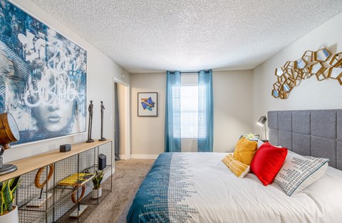 a bedroom with a large bed and a window with blue curtains