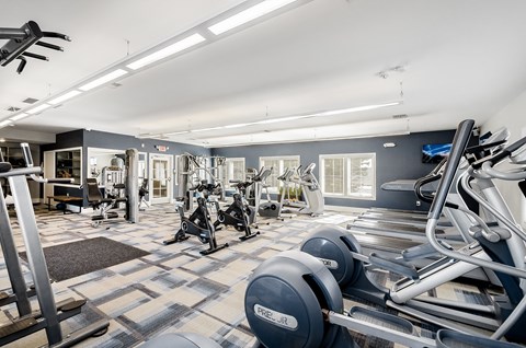 a gym with cardio machines and weights on a checkered floor