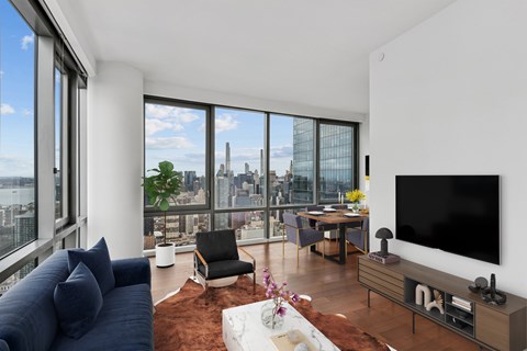 A modern living room with a large window overlooking the city.