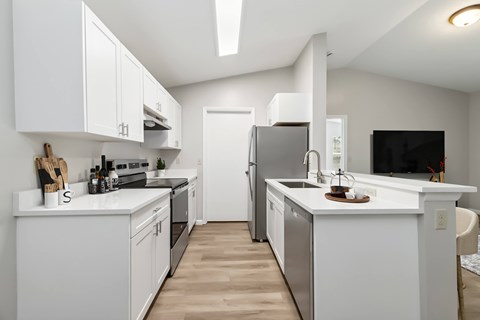 A modern kitchen with white cabinets and appliances.