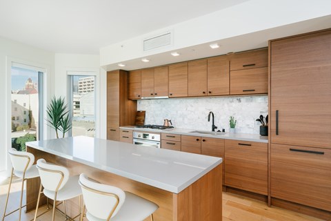 A modern kitchen with wooden cabinets and white countertops.