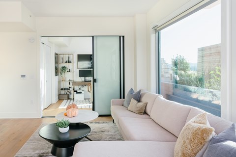 A modern living room with a white sofa and a black coffee table.