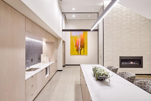 A modern kitchen with a long table and chairs.