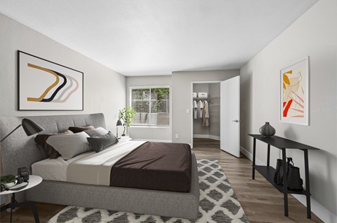 A bedroom with a large bed and a painting on the wall.