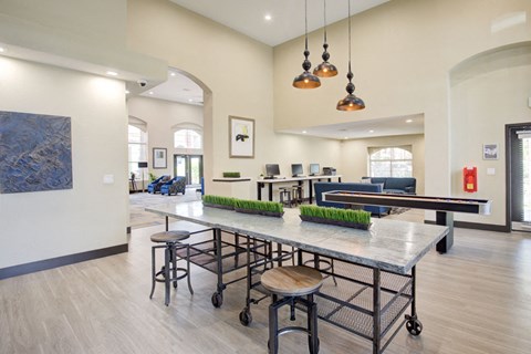 A modern kitchen with a long table and bar stools.