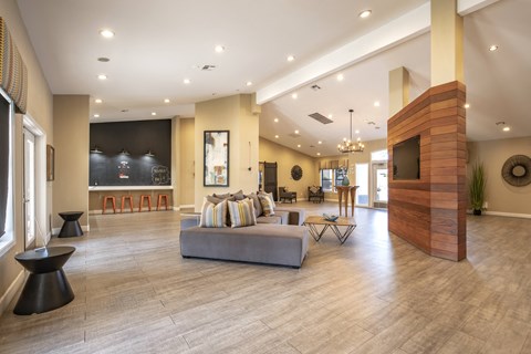 A living room with a grey couch and a wooden fireplace.