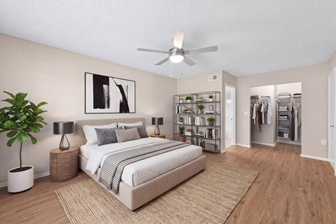 A bedroom with a bed, a plant, and a ceiling fan.