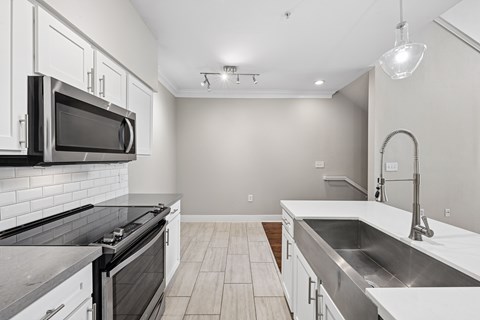 A modern kitchen with a black oven and white cabinets.