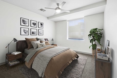 A bedroom with a large bed and a ceiling fan.