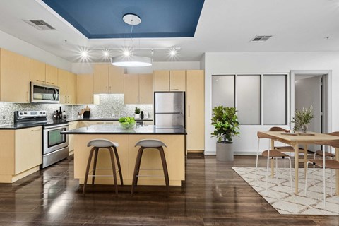 A kitchen with wooden floors and a blue ceiling.