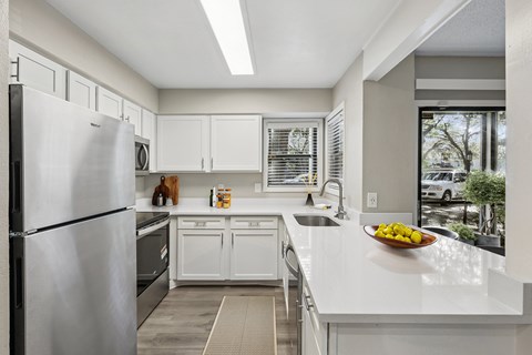 A modern kitchen with white cabinets and appliances.