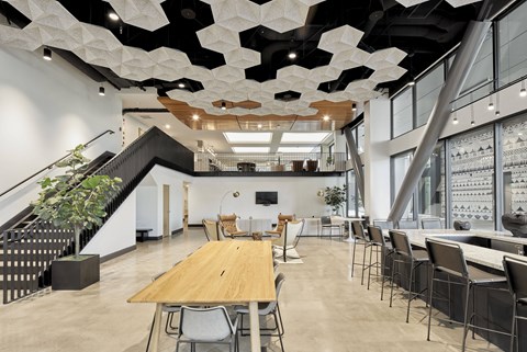 A modern dining room with a long wooden table and chairs.