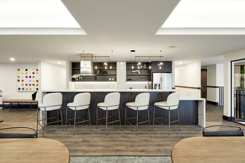 A modern kitchen with white chairs and a wooden table.