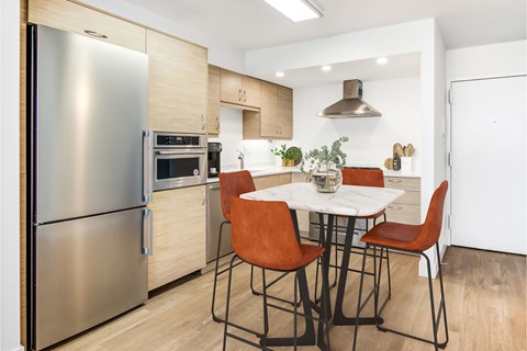 A modern kitchen with a table and chairs.