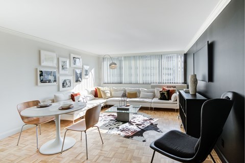 A modern living room with a white dining table and a white sofa.