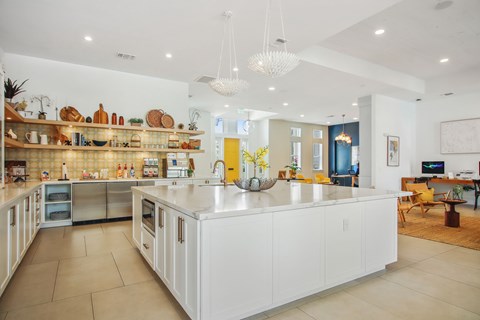 A kitchen with white cabinets and a large island.