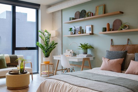 A bedroom with a large bed and a desk with a chair.