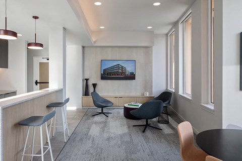 a living room with a table and chairs and a television on the wall