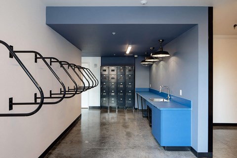 A kitchen area with a blue counter and a staircase on the left.