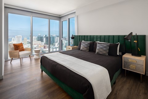 A bedroom with a large bed and a view of the city.