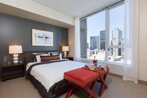 a bedroom with a bed and a large window