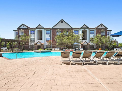 A large building with a pool in front of it.