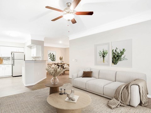 A living room with a white couch and a ceiling fan.