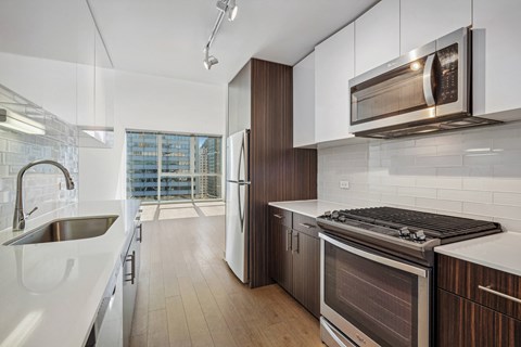 A modern kitchen with a stainless steel refrigerator and oven.