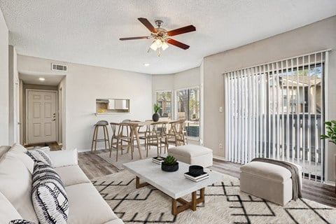A living room with a white couch and a ceiling fan.