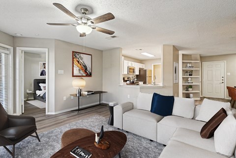 A living room with a white couch and a brown coffee table.