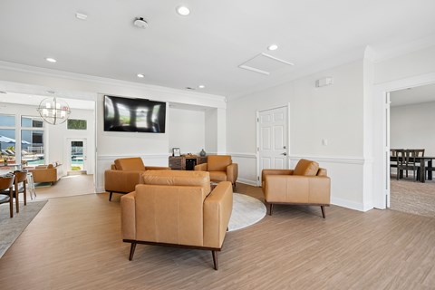 A living room with a large screen tv and comfortable seating.